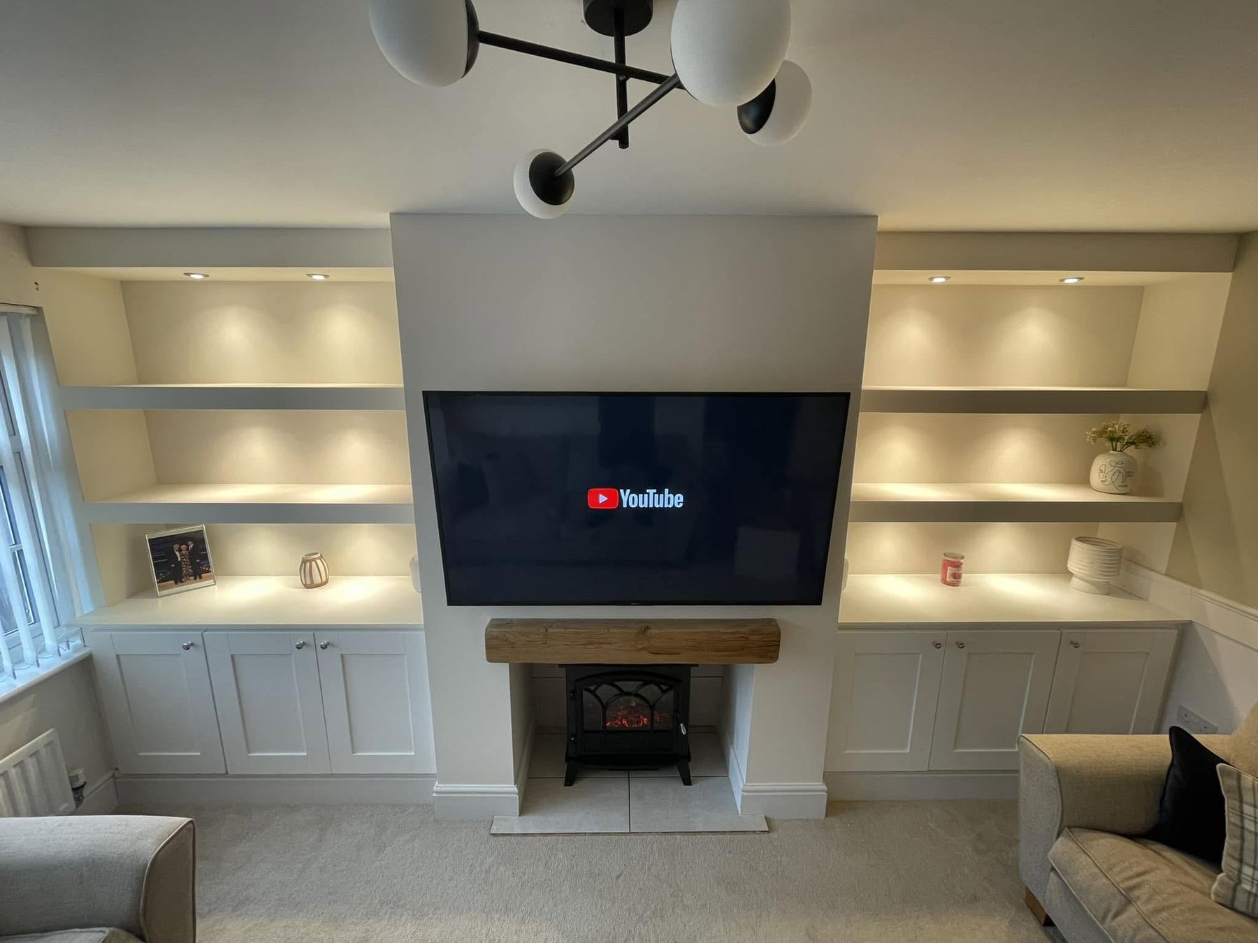 Bespoke alcove units and media wall with lit floating shelves, built by CPB Carpentry in Leicester